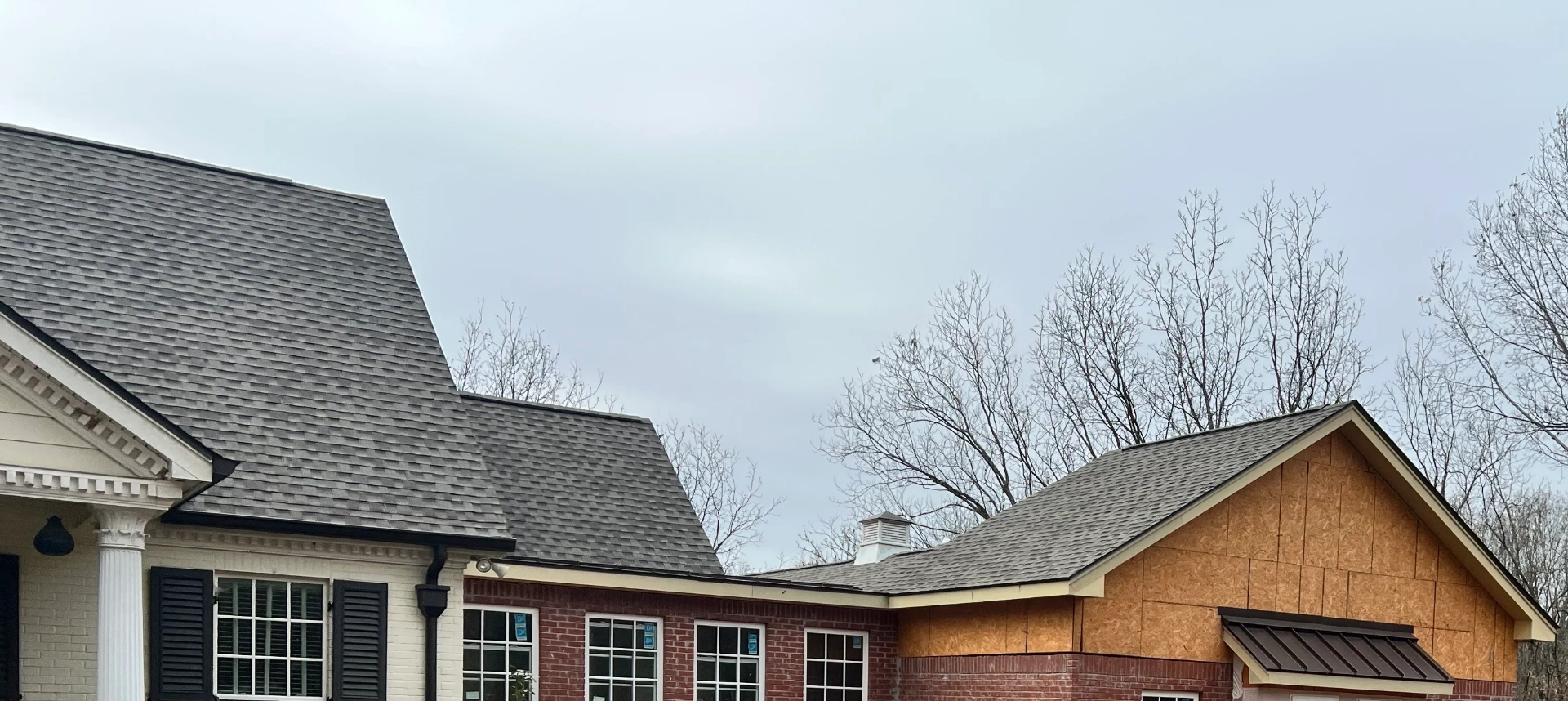 Mid-installation shot showing new shingles replacing old roof on home in Columbus MS